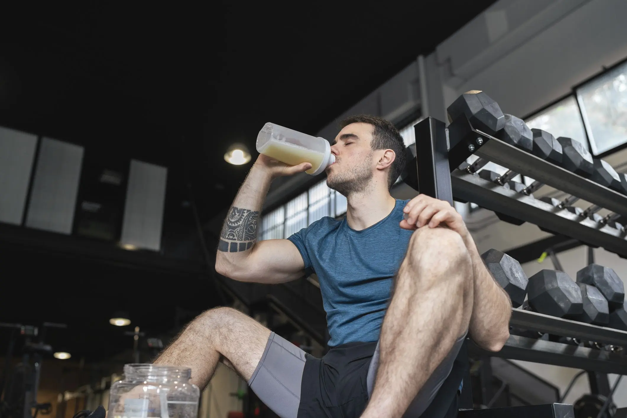 Men drinking whey in the gym