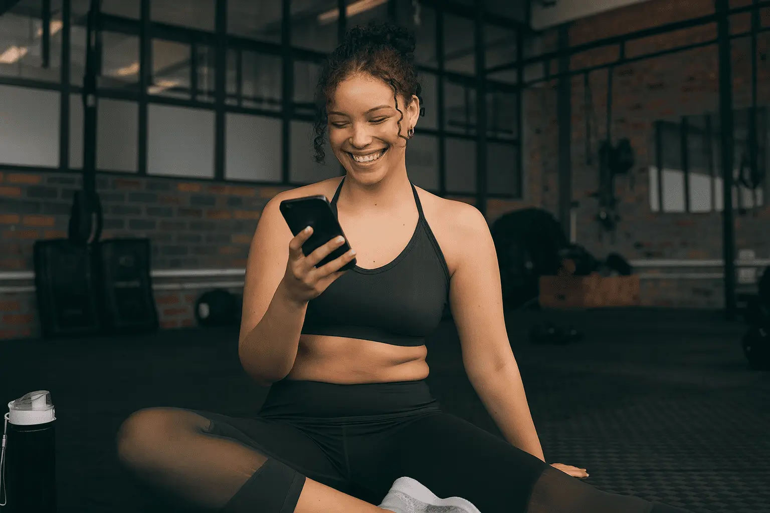 Women smiling using phone on Gym in Fitsse app